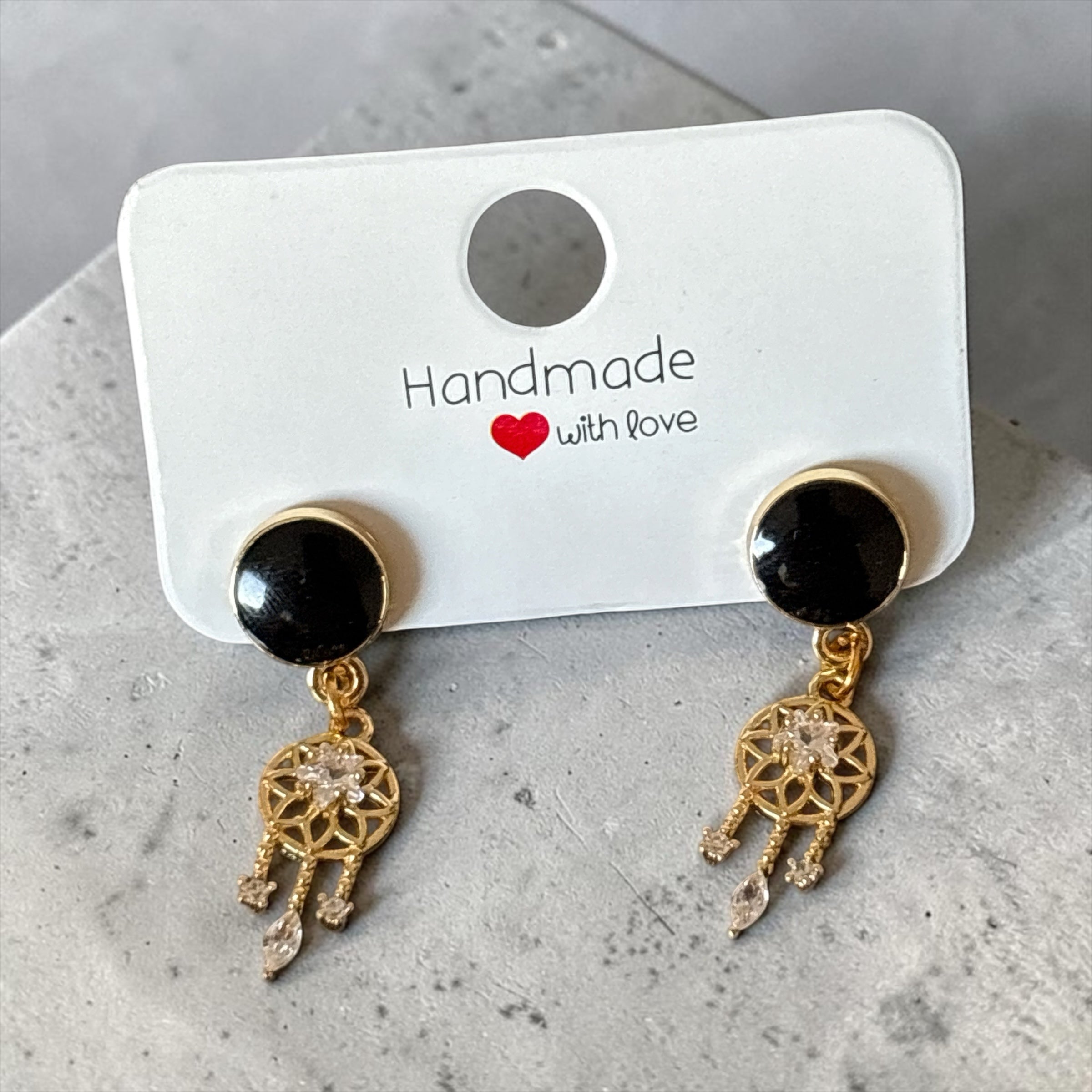 Boucles d'oreilles pendantes La boutique d'Emma avec cabochon noir, pampille dorée attrape-rêves et cristaux