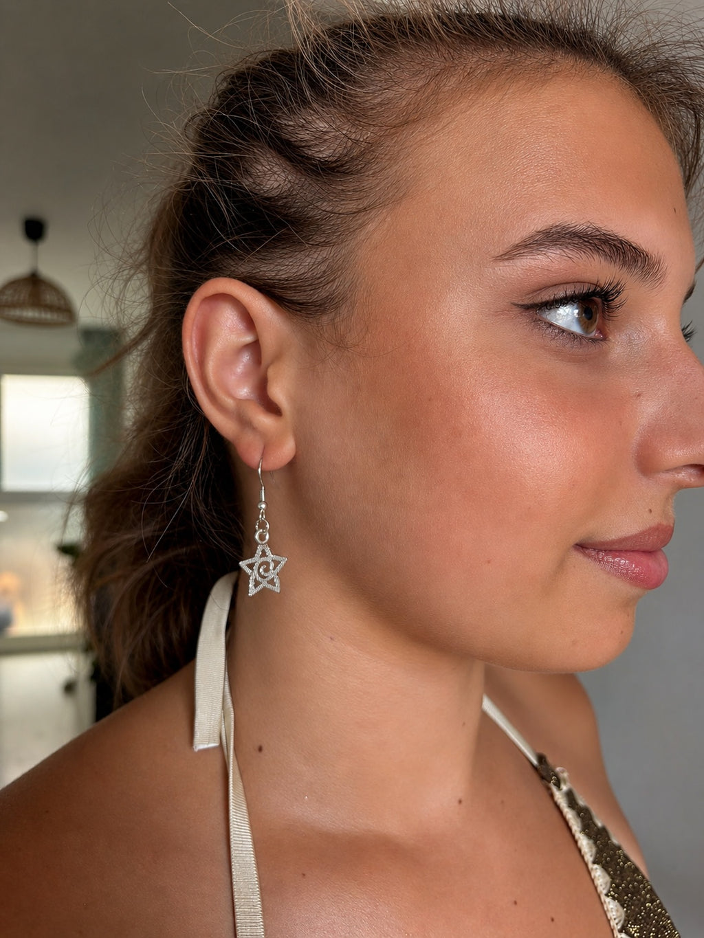 Boucles d'oreilles pendantes étoile La boutique d'Emma en métal argenté avec spirale centrale portées par une femme