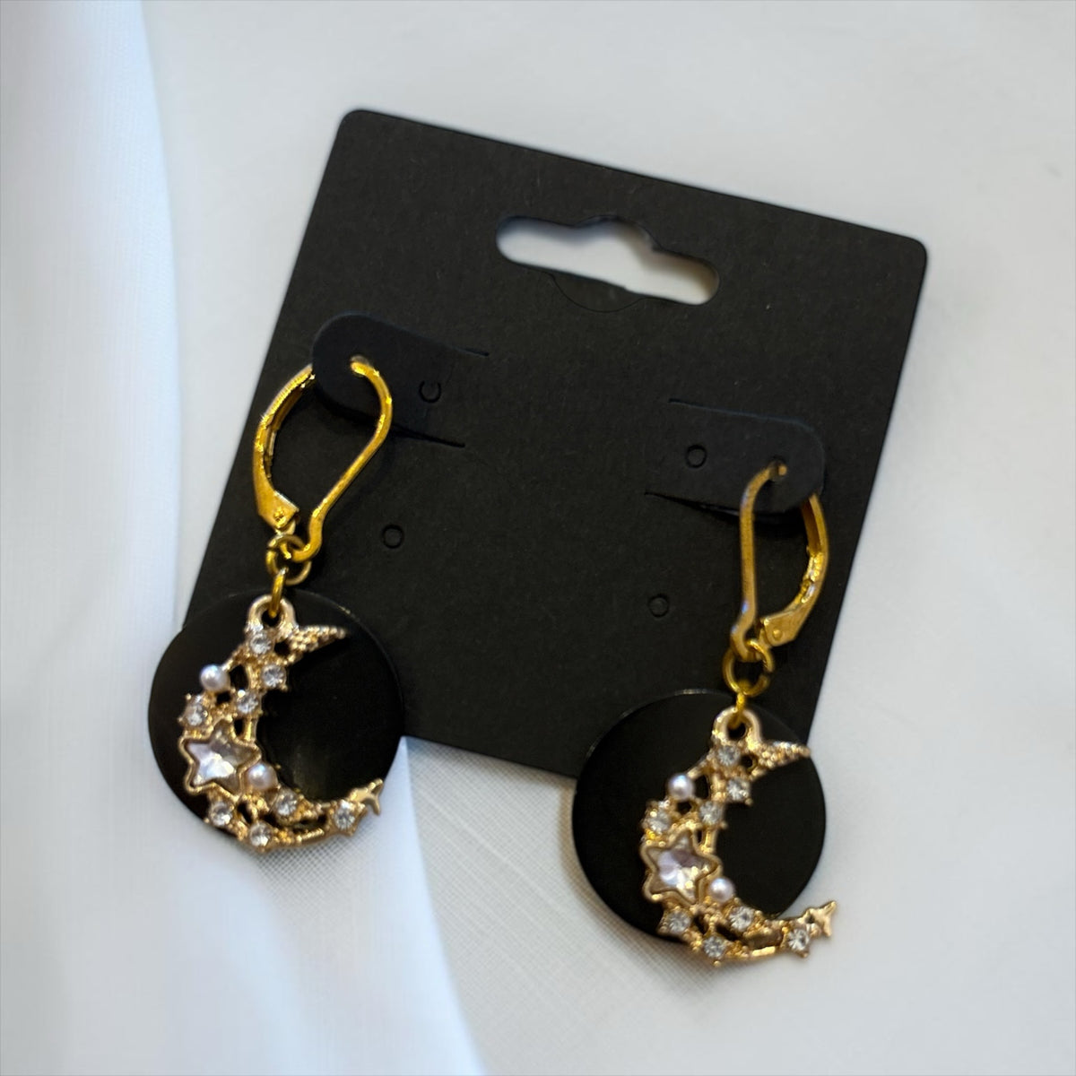 Boucles d'oreilles La boutique d'Emma pendantes dorées avec croissant de lune, cristaux et perles sur disque noir