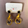 Boucles d'oreilles La boutique d'Emma dorées avec motif main tenant un anneau et perle sombre sur clou noir