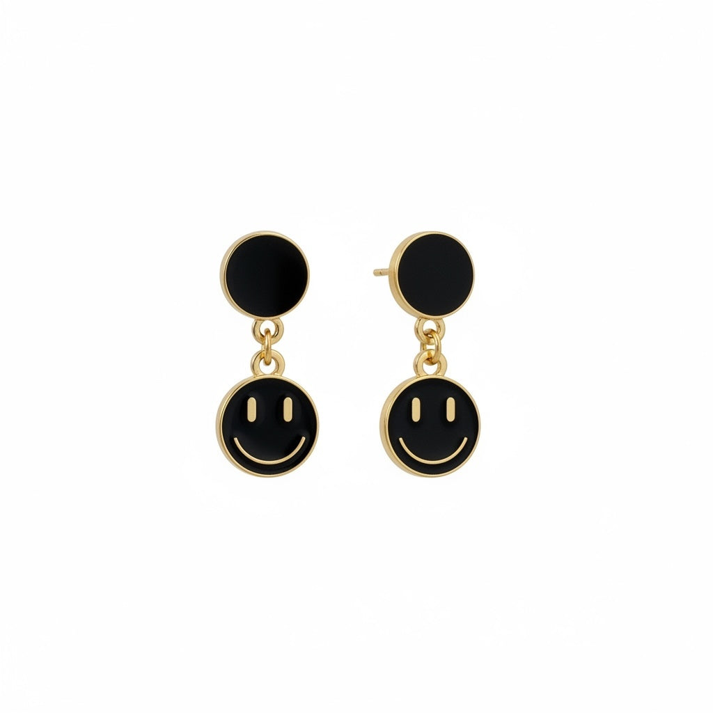 Boucles d'oreilles pendantes La boutique d'Emma dorées avec motif smiley en émail noir, design ludique et moderne.
