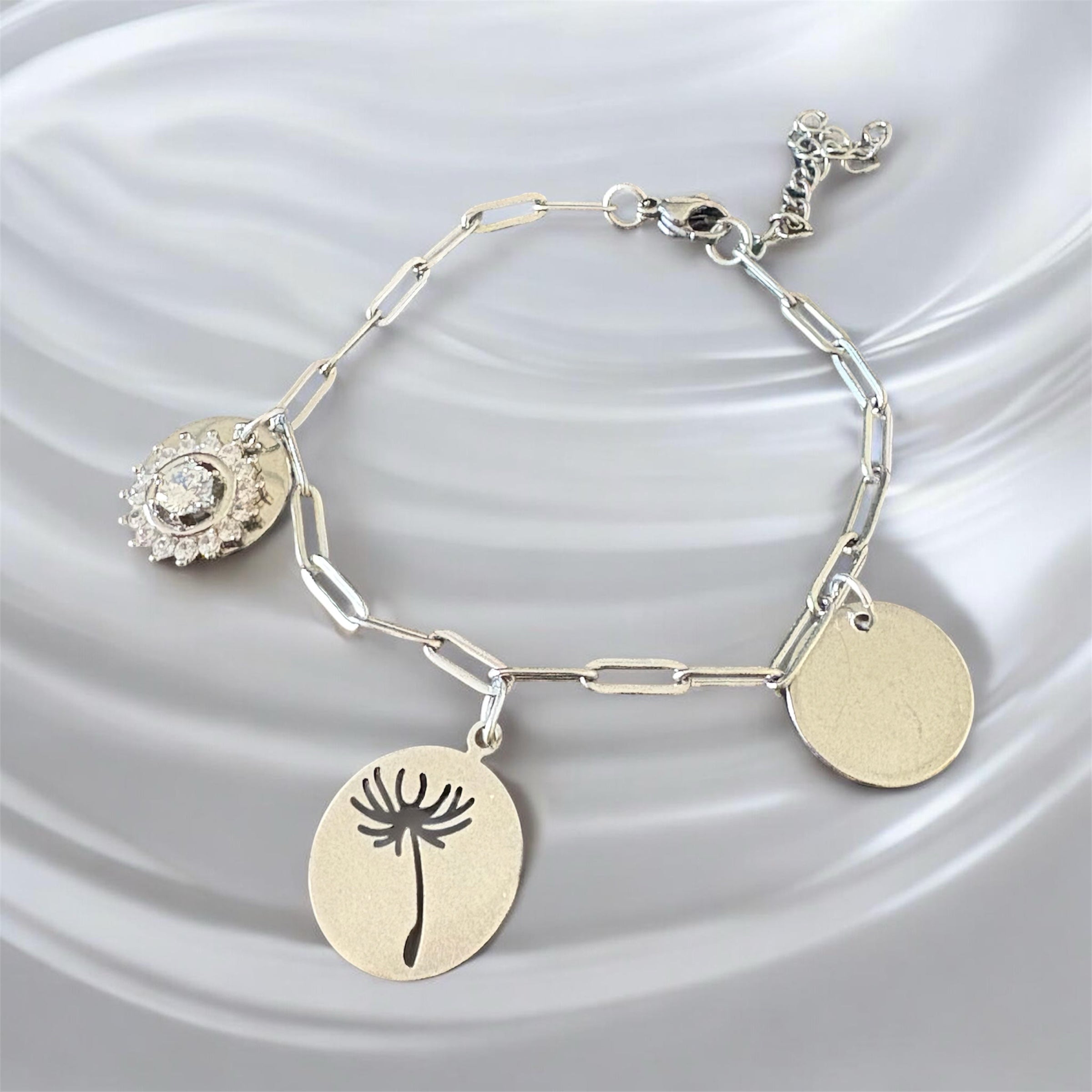 Bracelet La boutique d'Emma en métal argenté avec trois breloques : cristal, pissenlit gravé et médaillon lisse.