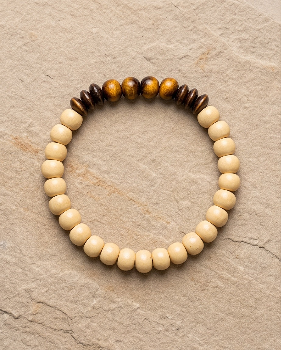 Bracelet La boutique d'Emma en perles de bois clair et perles en bois sombre sculpté sur fond texturé beige