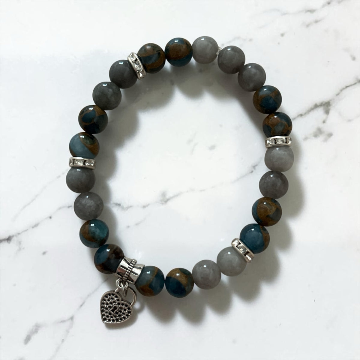 Bracelet La boutique d'Emma en perles naturelles grises et bleues avec intercalaires strass et breloque cœur argentée
