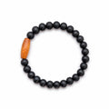 Bracelet élastique La boutique d'Emma en perles noires mates avec une perle centrale en bois sculpté