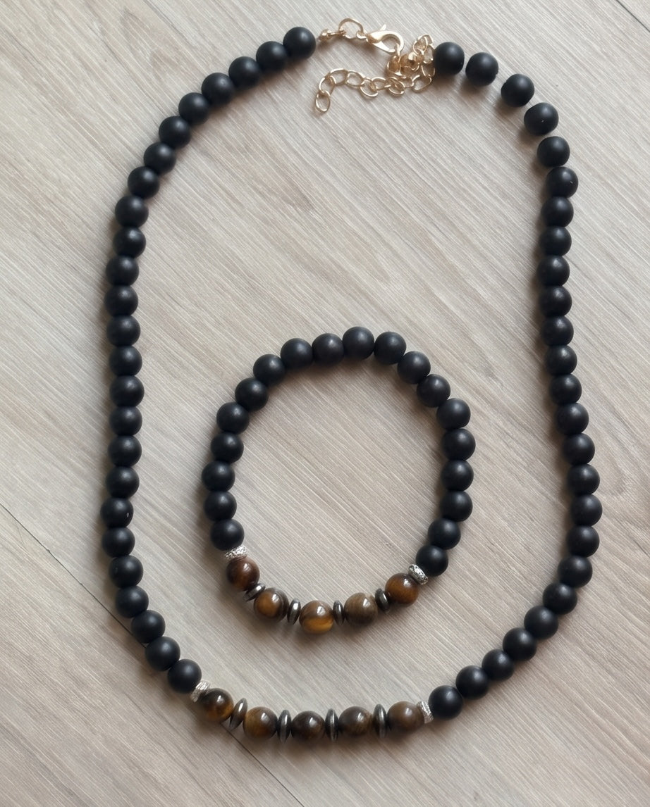 Parure La boutique d'Emma composée d'un collier et d'un bracelet en perles noires mates et pierres œil de tigre.
